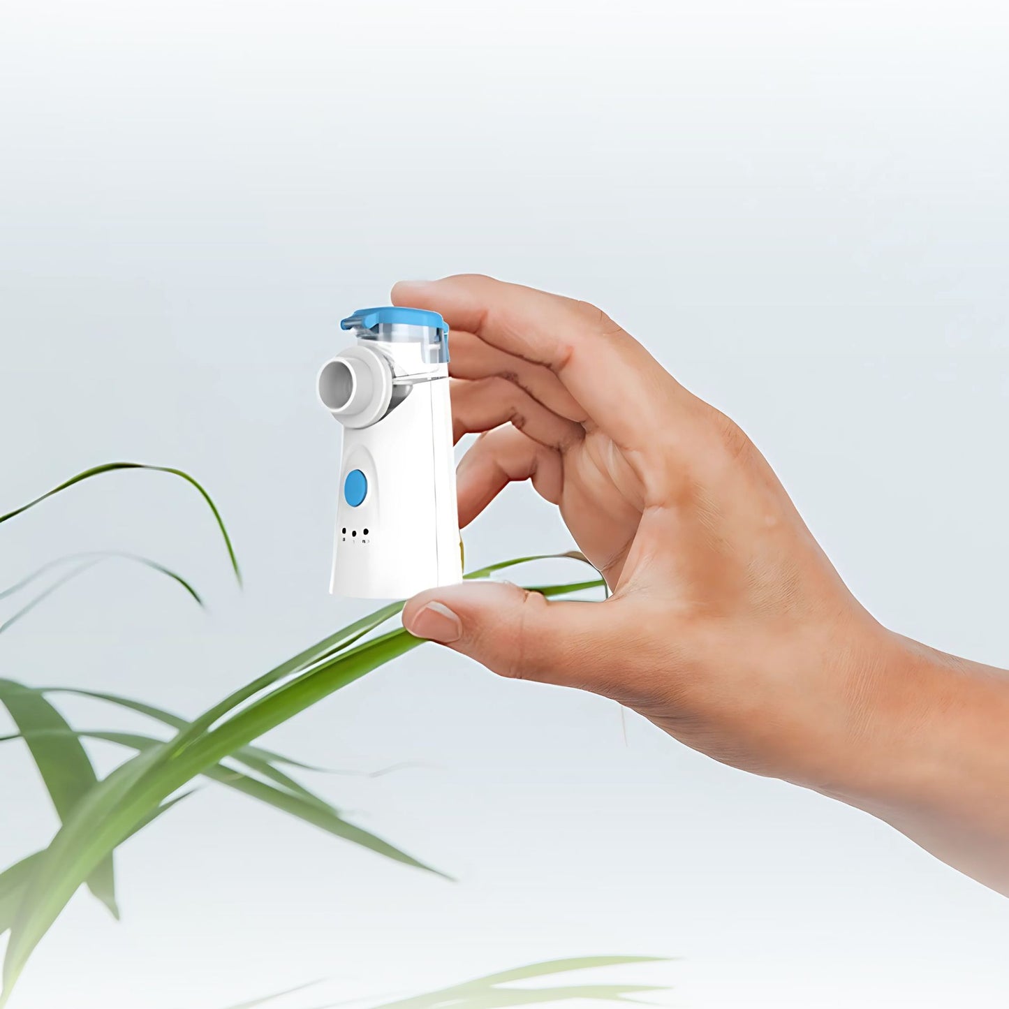 Hand holding compact MediWares nebulizer to demonstrate portable size